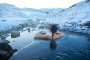 Woman soaking in hot spring in winter 