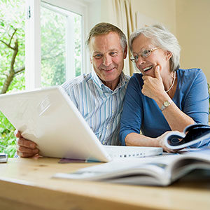 older couple looking at computer and guidebooks