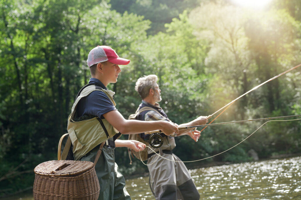 A father and his son fly fishing in summer 
