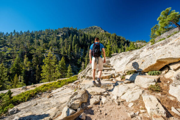 Tourist with backpack hiking in mountains at Lake Tahoe in California, USA